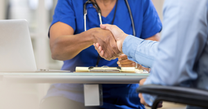 A doctor shakes a patient's hand.